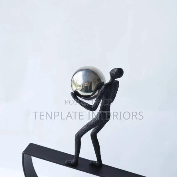 Man Balancing With Ball Sculpture photo 3